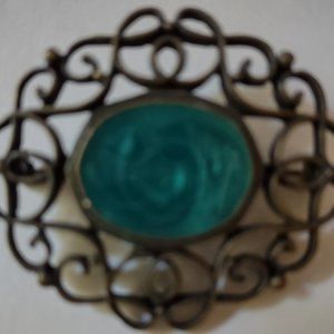 Vintage brooch, green stone encased in lacy antique gilt color metal.